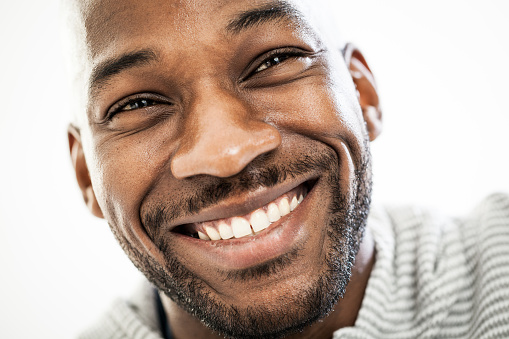 Close up portrait of a happy black man in his 20s isolated on a white background