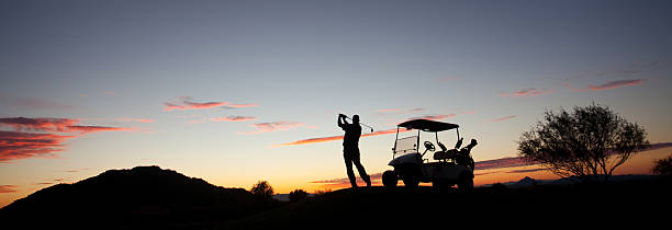 männliche kaukasier golfspieler schwingen golf club mit golfwagen - playing golf fotos stock-fotos und bilder