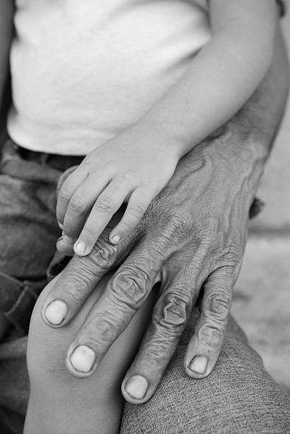 baby boy's fingers touching the palm of his father's upturned hand, New York, NY