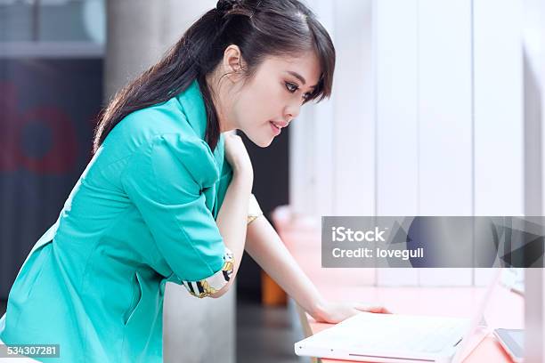 Asian Successful Office Lady Using Laptop In Office Interior Stock Photo - Download Image Now