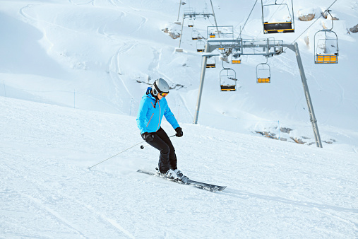 Teenage girl snow skier skiing on sunny ski resorts