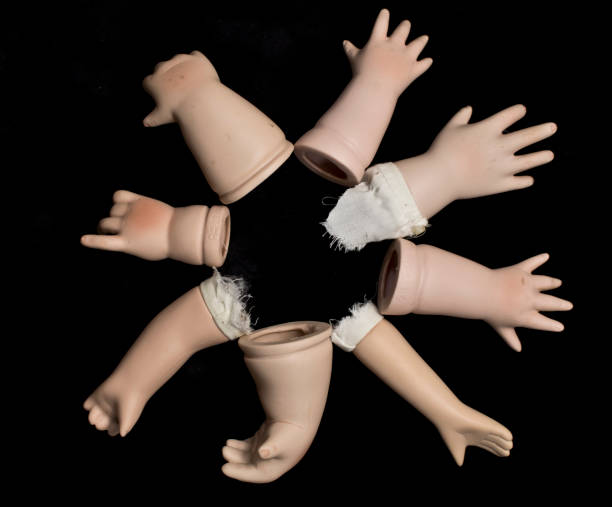 istock Broken Doll Body Parts on Black Background 534308504