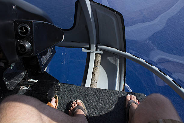 Person riding in a Helicopter over the Pacific Ocean on a sightseeing tour from Hawaii, view of a man's feet flip flops with water of Pacific Ocean below