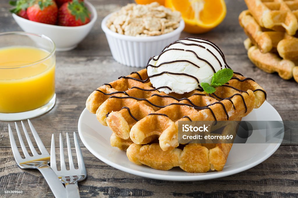 Breakfast. Waffles with ice cream Waffles with ice cream, strawberries and orange juice Baked Stock Photo