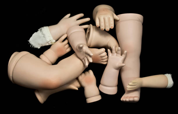 istock Broken Doll Body Parts on Black Background 534309980