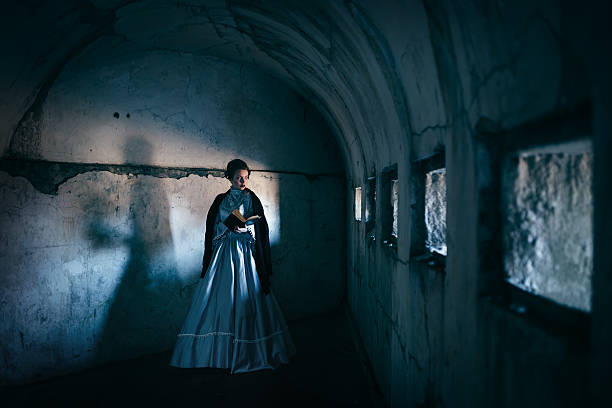 Woman in victorian dress imprisoned in a dungeon