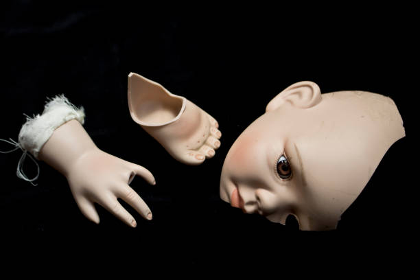 istock Broken Doll Body Parts on Black Background 534310292