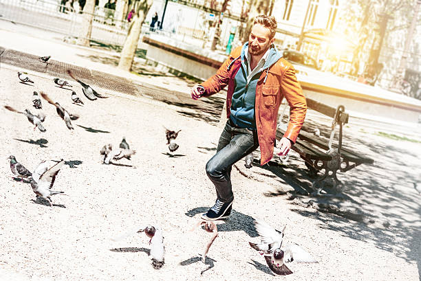 istock happy  bearded man running on Paris square with doves 534310308
