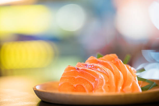 istock Sliced salmon sashimi served on wooden platter, bokeh background 534312300