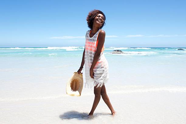 atractiva mujer joven caminando en el agua en la playa - one person beautiful barefoot beach fotografías e imágenes de stock