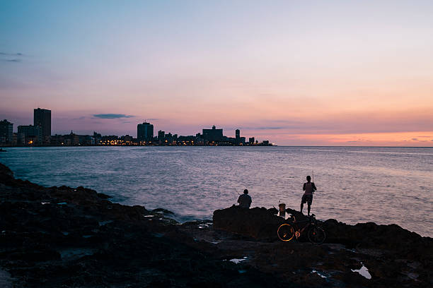 rybak na malecon o zmierzchu, hawana, kuba - capital cities retaining wall malecon coastline zdjęcia i obrazy z banku zdjęć