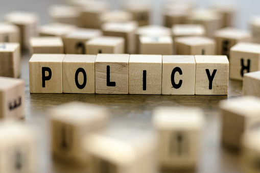 The word Policy on wood blocks building.