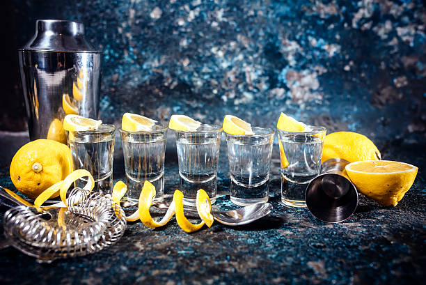 colpi di tequila d'argento con fette di limone ed elementi cocktail. - tequila shot tequila salt lemon foto e immagini stock