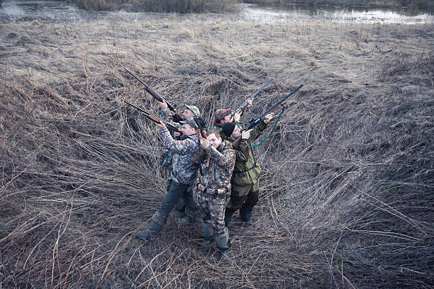 istock Group of hunters standing back to back in rural field 534318874