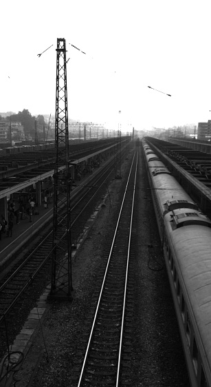 Shaoguan, China - October, 20th, 2014: general view of the railways, travellers standing on the platforms and trains on a typical smoggy day in the south of China.