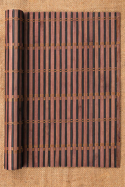 Bamboo mat twisted in the form of a manuscript Bamboo mat twisted in the form of a manuscript on sackcloth, with space for your text bamboo twist stock pictures, royalty-free photos & images