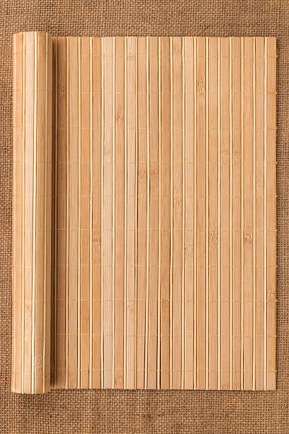 Bamboo mat twisted in the form of a manuscript Bamboo mat twisted in the form of a manuscript on sackcloth, with space for your text bamboo twist stock pictures, royalty-free photos & images