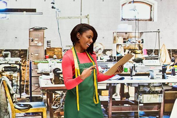 istock Cheerful seamstress pointing at clipboard in factory 534321712