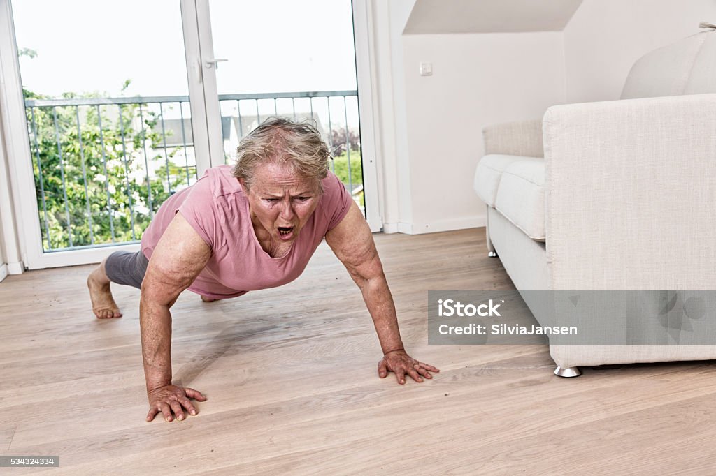 active senior woman with overweight exercising Senior woman doing Pushups in living room One Woman Only Stock Photo