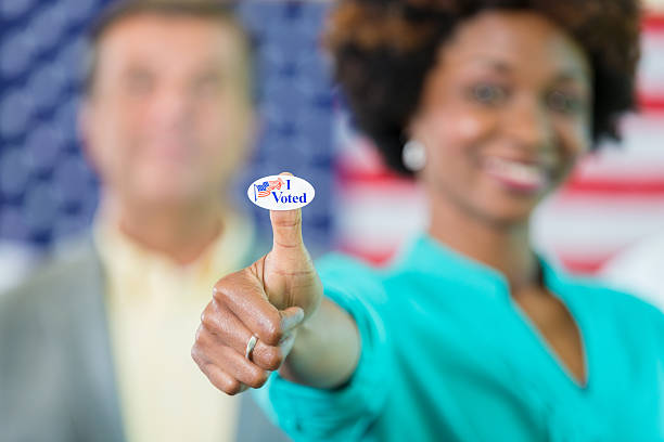 istock Voter gives a thumbs up with I voted sticker 534324674