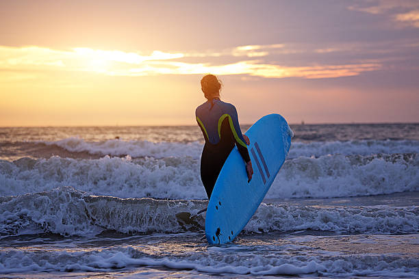 istock Beautiful middle aged female surfing at dusk 534324918