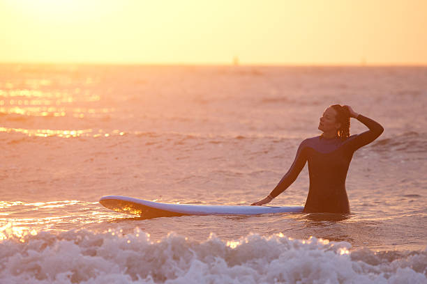 istock Beautiful middle aged female surfing at dusk 534324954