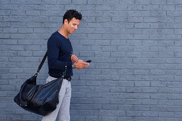 istock Handsome man traveling with bag and cell phone 534325072