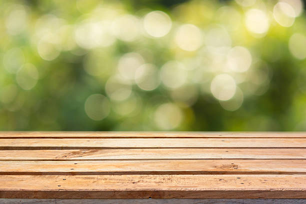 Empty wooden deck table on bokeh natural background stock photo
