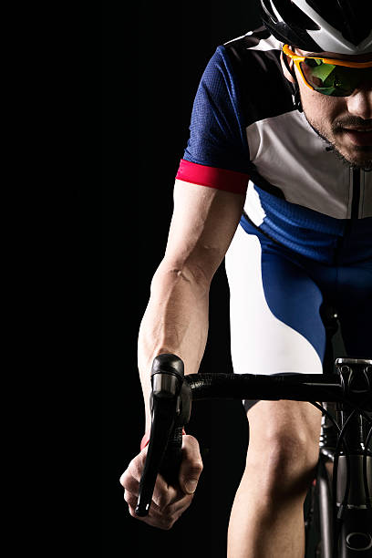 istock Handsome young man cycling indoor. Isolated on black. 534327350