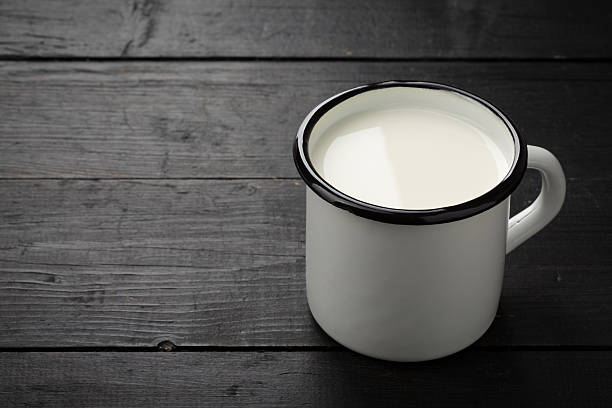 istock Black weathered wooden board with white tin cup. 534327498