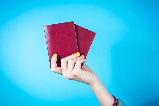 istock Womans hand holding a two passports against blue background 534327856