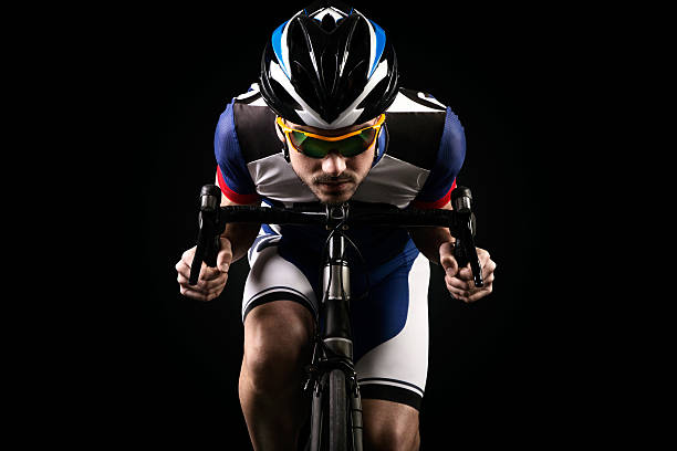 istock Handsome young man cycling indoor. Isolated on black. 534328164