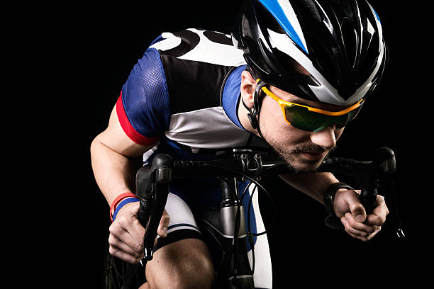 istock Handsome young man cycling indoor. Isolated on black. 534328234
