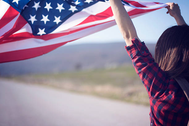 istock Girl flying American flag on wind 534328934