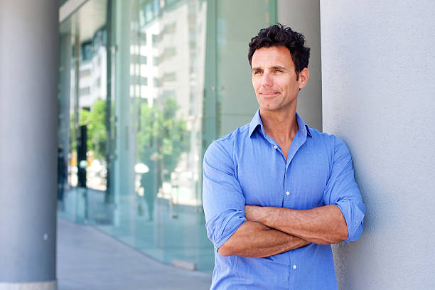 Business man standing outside with arms crossed Portrait of a business man standing outside with arms crossed businessman happiness outdoors cheerful stock pictures, royalty-free photos & images
