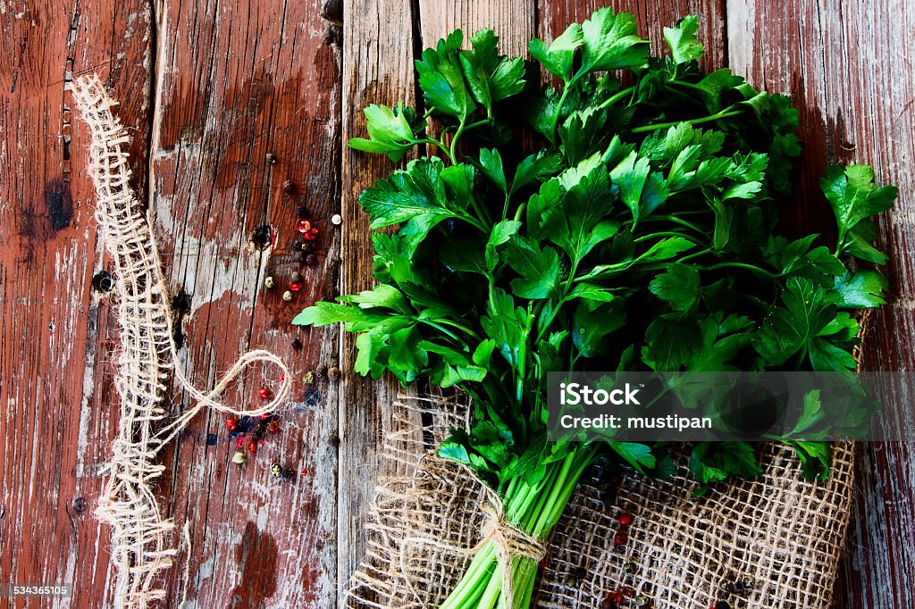 parsley Organic parsley on jute and wooden texture. Top view. 2015 Stock Photo