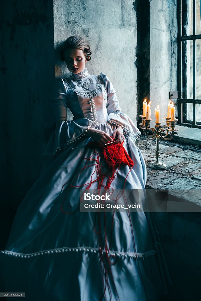 Woman in victorian dress Woman in victorian dress imprisoned in a dungeon Women Stock Photo