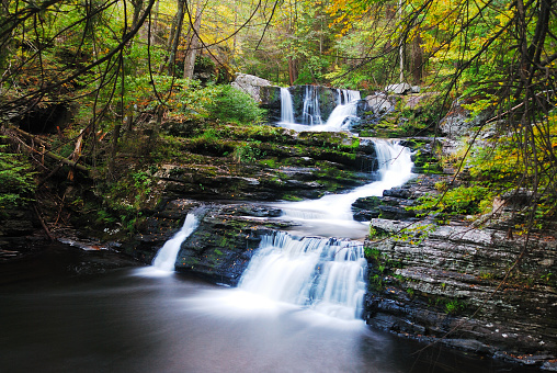 Waterfall with trees and rocks in forest in mountain in Autumn. From Pennsylvania Dingmans Falls.