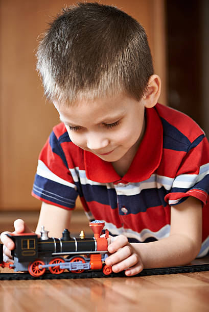 istock Little boy playing with railway lying on floor 534366977