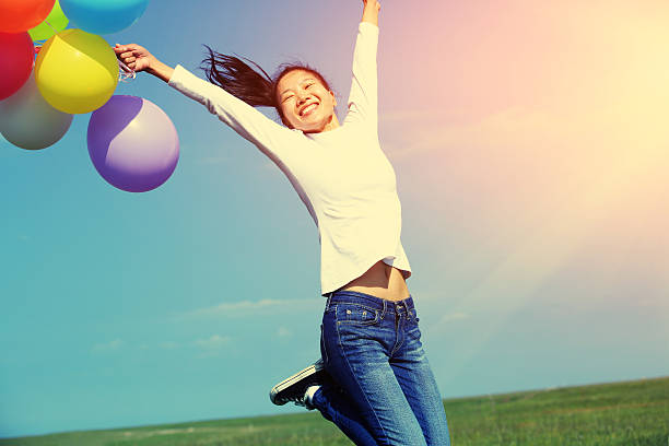 istock young asian woman jumping with colored balloons 534367001
