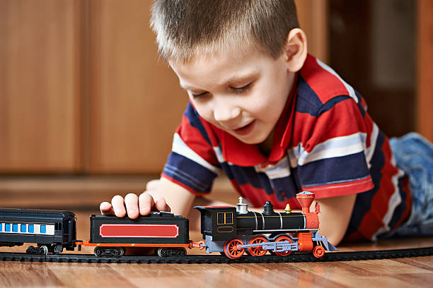 istock Little boy playing with railway lying on floor 534367009