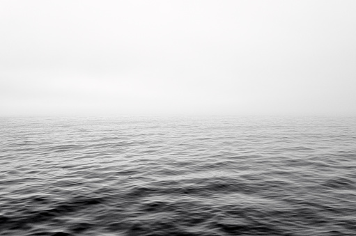 Dramatic gray mist clouds over sea wave. Horizon, half sea, mist