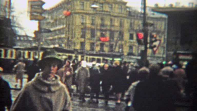 1966: Crowded urban european scene of people walking past mass transit trains.