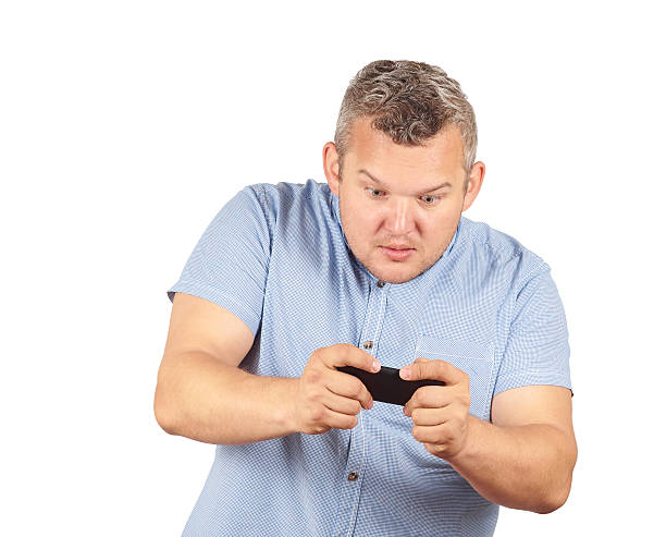 istock fat man looks at the phone. 534399686
