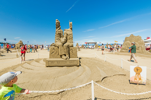 British Columbia, Canada - July 14, 2015: Tourists and locals come to see the winning sand sculpture of Batmand and Joker at the annual sand sculpture competition in Parksville, Vancouver Island