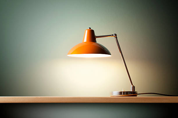 Desk lamp Retro orange desk lamp on the table. electric lamp stock pictures, royalty-free photos & images