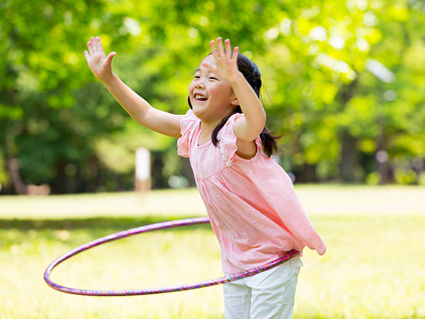 Little girl playing with Plastic Hoop stock photo