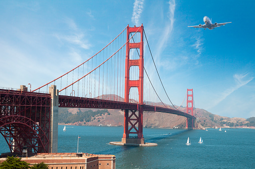 Commercial airplane flying over the Golden Gate Bridge in San Francisco