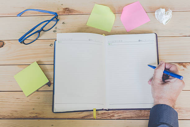 istock Male hands with notebook and stickers on wooden table 534409046