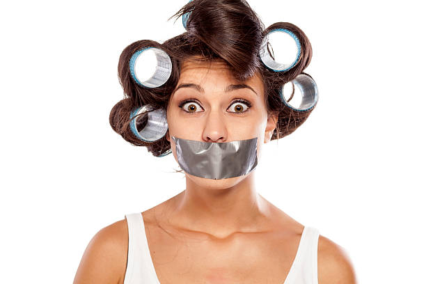 überrascht hausfrau mit lockenwickler und klebeband auf ihren mund - human mouth duct tape covering adhesive tape stock-fotos und bilder